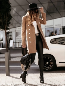 Detail of camel double-breasted wool coat with gold buttons and a classic lapel collar