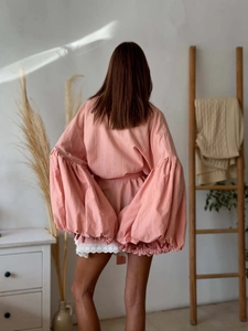 Detailed back view of pink lantern sleeve shirt with delicate white lace trim hemline