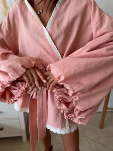 Close-up of pink kimono blouse featuring lace trim and oversized puff lantern sleeves