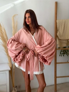 Close-up of pink lace-up shirt featuring lantern sleeves and delicate white lace trim details