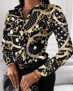 Detail of elegant black long sleeve blouse with golden chain print and satin finish