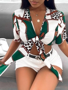 Dettaglio della camicia con scollo a V, nodo frontale e stampa a catena e leopardo bianco