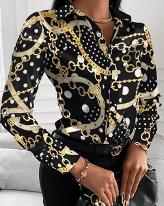 Close-up of elegant black satin blouse featuring gold chain prints and white polka dots