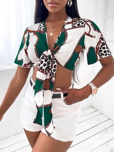 Dettaglio del crop top a maniche corte con scollo a V, stampa catena e leopardata