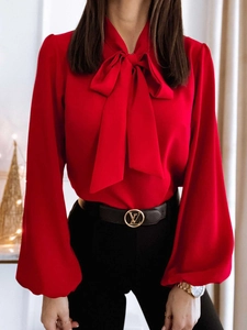 Detail of red chiffon shirt with large bow neck tie and elegant lantern sleeves