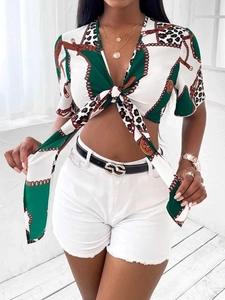 Dettaglio crop top con lacci e stampa catena leopardata e pantaloncini di denim bianchi