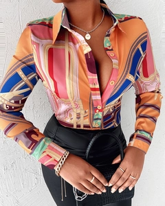 Détail d'une chemise à imprimé chaîne géométrique colorée avec bijoux dorés