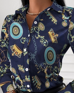 Detail of baroque print shirt with gold crown motifs and white buttons on dark blue fabric