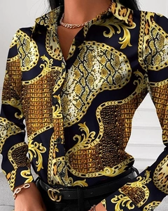 Detail of baroque gold scroll and snakeskin print on women's long sleeve blouse