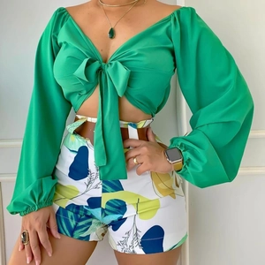 Détail d'un haut court vert à manches longues avec nœud et short à imprimé tropical