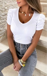Detailed close-up of V-neck white ribbed knit top with elegant puff sleeves on model