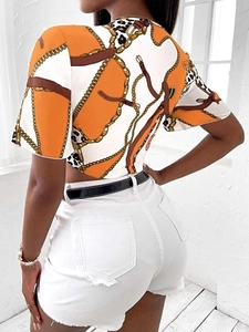 Dettaglio del crop top con stampa a catena e accenti decorativi in stile leopardo