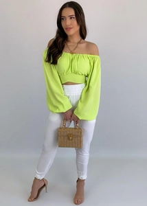 Détail du crop top vert fluo à épaules dénudées avec manches ballon et liens à nouer