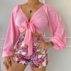Vue détaillée du haut rose à col en V et du short à fleurs avec ceinture assortie