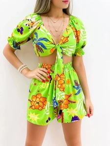Detail view of tropical floral print on green v-neck top and high-waisted shorts set