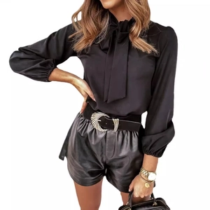 Elegant women's black pussy-bow blouse with long sleeves and leather shorts ensemble