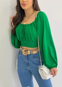 Détail de la blouse vert émeraude à manches bouffantes avec col carré et buste plissé