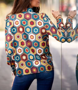 Detail of elegant long sleeve blouse featuring a geometric hexagon print with shiny fabric