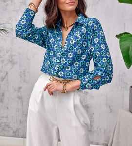 Close-up of elegant blue geometric floral print blouse with long sleeves and gold chain belt