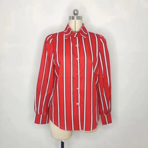 Détail d'un chemisier rayé à manches longues pour femme avec col boutonné et poignets larges