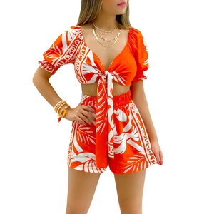 Detail view of tropical floral print fabric on the V-neck tie-front crop top and shorts
