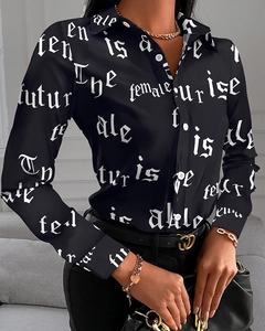 Nahaufnahme der schwarzen Bluse mit weißem Gothic-Schriftzug und seidiger Textur