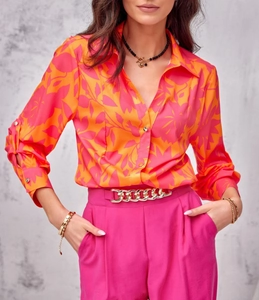 Detail of vibrant orange and pink floral shirt with gold chain belt and fuchsia pants