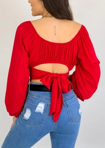 Détail du chemisier dos nu rouge avec grand nœud et manches bouffantes élégantes