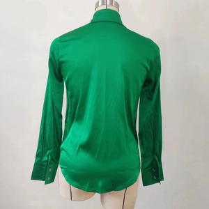 Vista posteriore dell'elegante camicia in raso verde smeraldo con taglio sciancrato