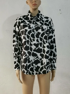 Détail du motif vache et des boutons métalliques sur une chemise décontractée à manches longues
