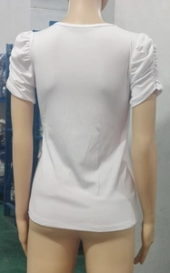 Back view of a white rib-knit top featuring textured puff sleeves and ruched shoulder details