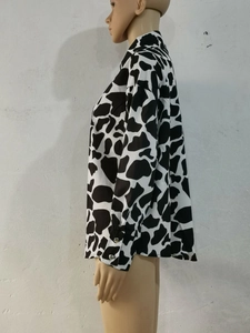 Détail d'une chemise à motif vache avec poignets boutonnés et tissu fluide soyeux