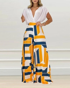 Détail du haut blanc col en V pour femme et du pantalon large à imprimé géométrique