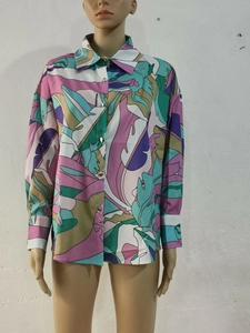 Détail de chemise à fleurs avec motifs de feuilles tropicales et boutons métalliques