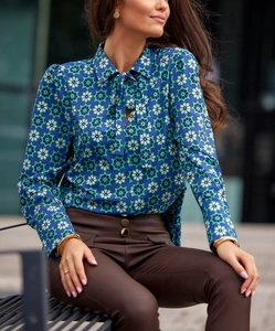 Detail of elegant pussy-bow blouse featuring geometric print and long cuffed sleeves