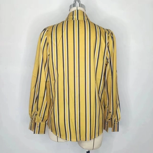 Détail du tissu à rayures verticales jaune, noir et blanc et de la construction du dos