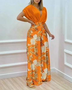 Détail du haut plissé orange à col en V et du pantalon large à imprimé floral de qualité