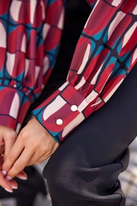 Détail du poignet de chemise avec imprimé géométrique rétro et boutons blancs