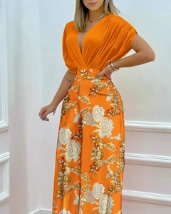 Détail du haut à col en V volanté et pantalon large à fleurs dans un orange éclatant