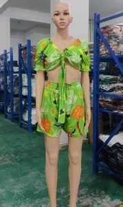 Detail of green tropical print two-piece set featuring puff sleeves and tie-front top