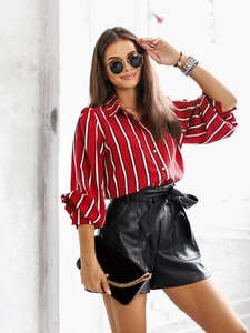 Détail de la manchette de chemise rayée rouge et short en cuir noir avec ceinture nœud