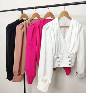 Detail view of V-neck wrap shirts with puff sleeves and gold buttons in four colors