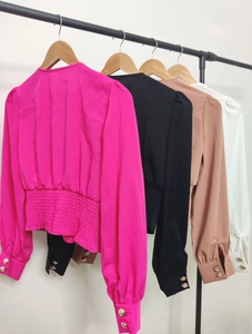 Close-up of smocked waist detail and gold buttons on puff sleeve chiffon blouses