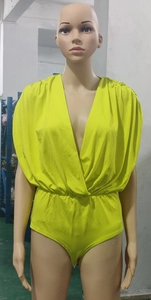 Détail d'un body vert fluo avec décolleté en V profond et épaules froncées