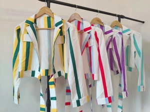 Détail de blazers courts à rayures avec revers, poches poitrine et liens à la taille