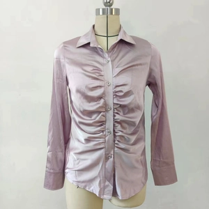 Dettaglio camicia in raso viola chiaro con increspature e finitura effetto seta