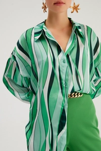 Dettaglio della camicia in chiffon a onde verdi con strisce verticali e colletto