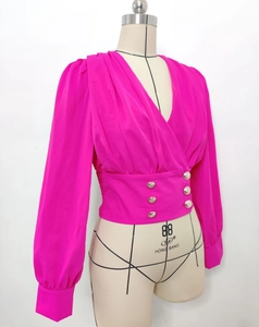 Detail of rose red V-neck blouse featuring pleated bubble sleeves and golden buttons