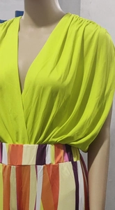 Détail du haut plissé vert fluo à col en V et du pantalon à rayures multicolores