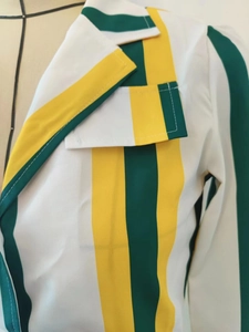 Détail du revers du blazer à rayures et coutures en blocs de vert, jaune et blanc